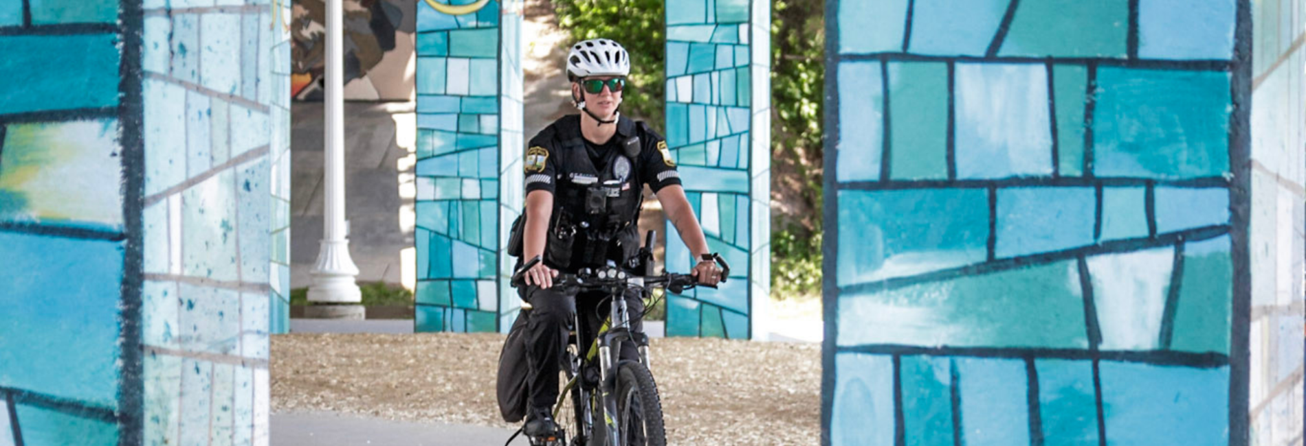 Police officer on bicycle riding through underpass near Rudee Loop