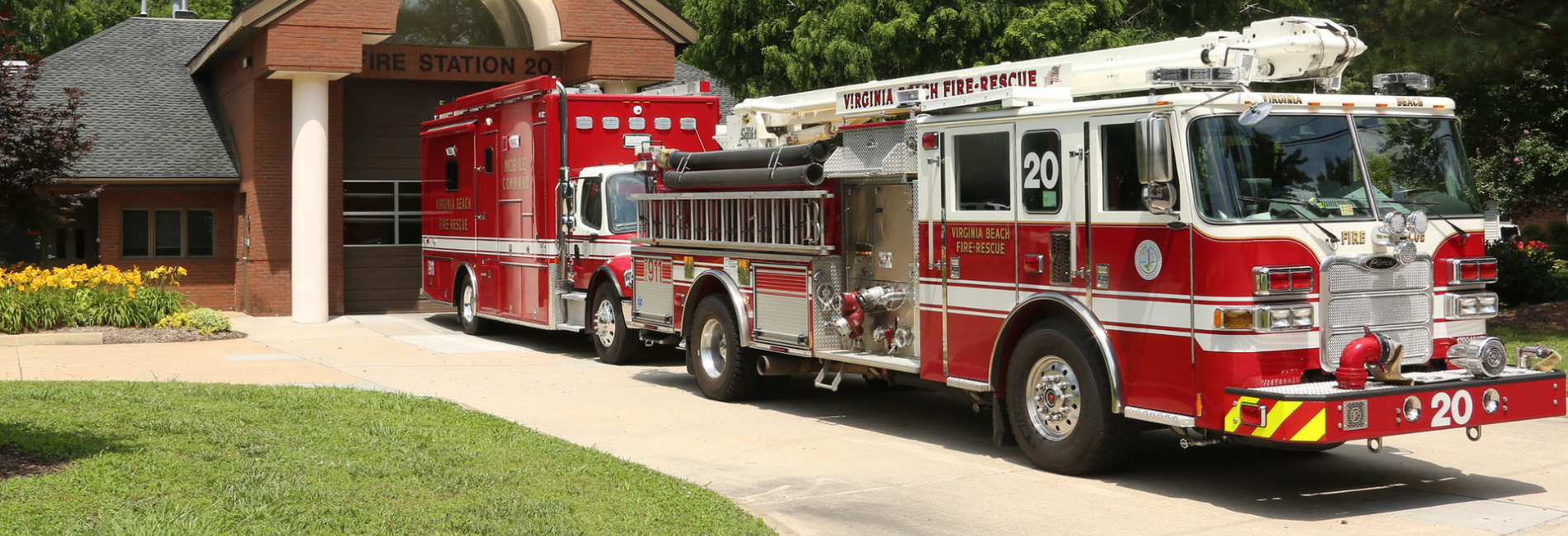 Fire truck and equpiment vehicle parked in front of fire station