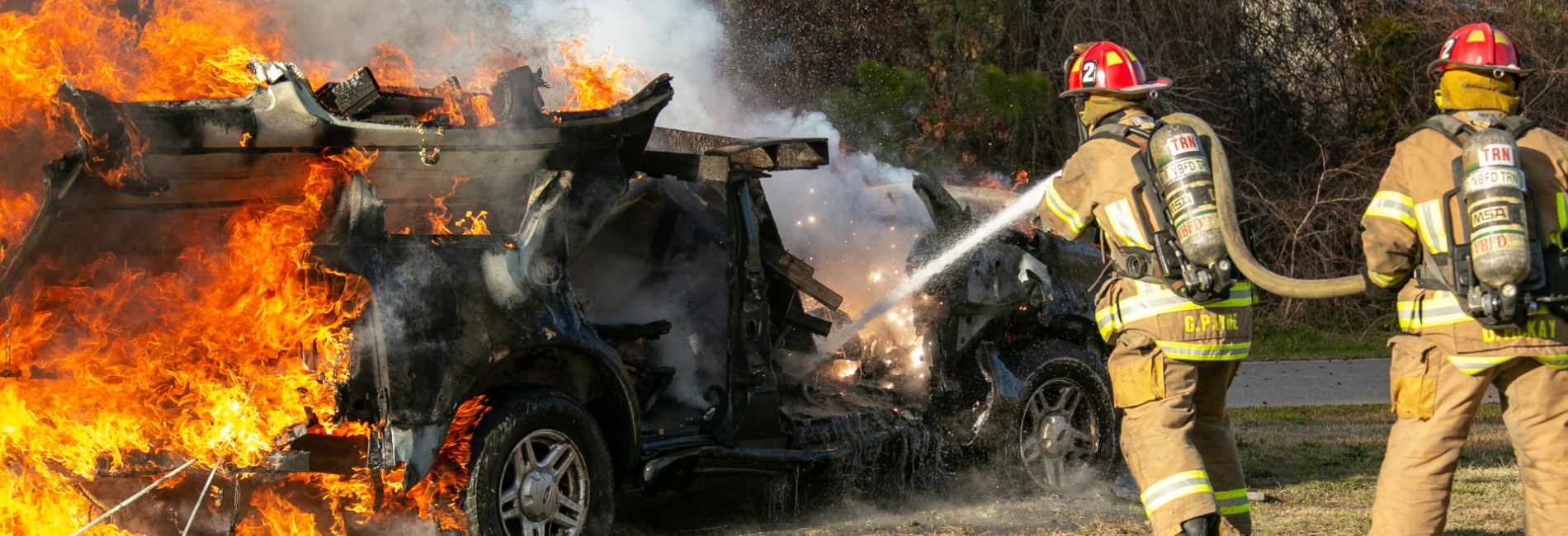 Two firefighters extinguishing SUV on fire