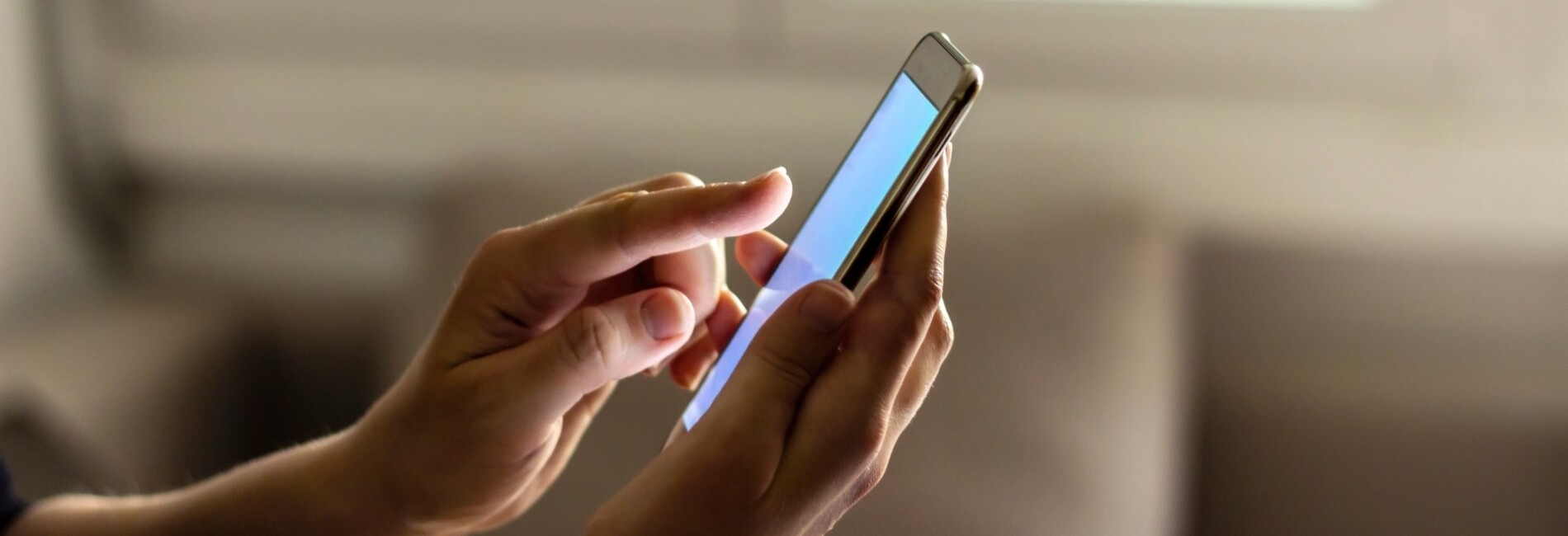 Close up of phone in persons hand with other hand touching screen